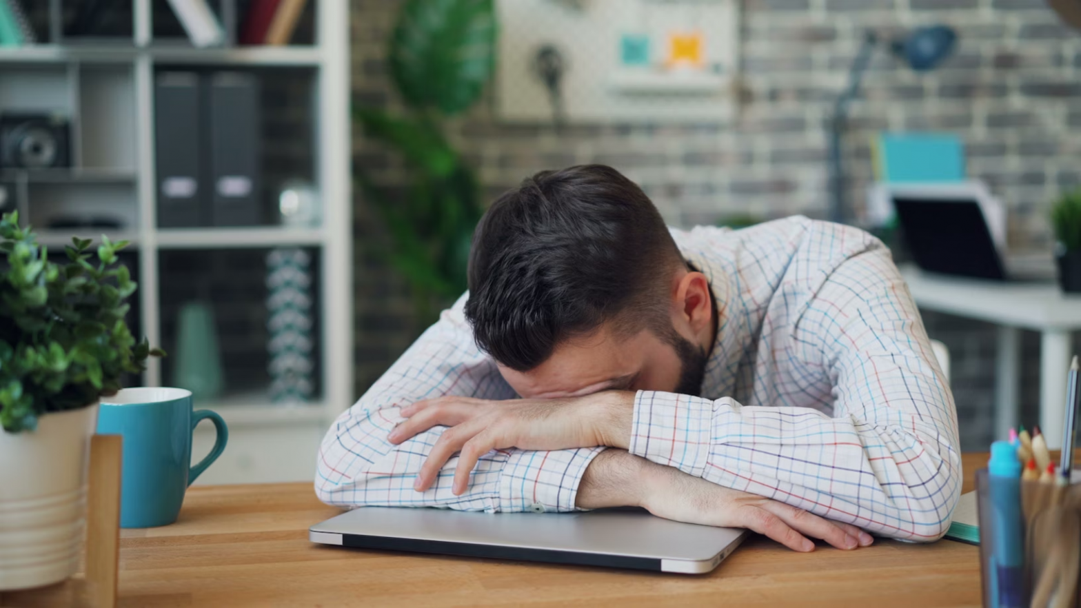 Man resting head on laptop